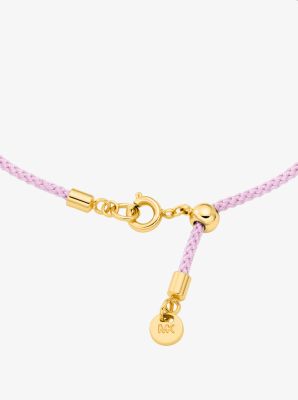 Pulsera de cord&oacute;n con logotipo e incrustaciones de pav&eacute; en tono dorado