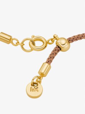 Pulsera de cord&oacute;n con logotipo e incrustaciones de pav&eacute; en tono dorado