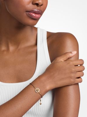 Pulsera de cord&oacute;n con logotipo e incrustaciones de pav&eacute; en tono dorado